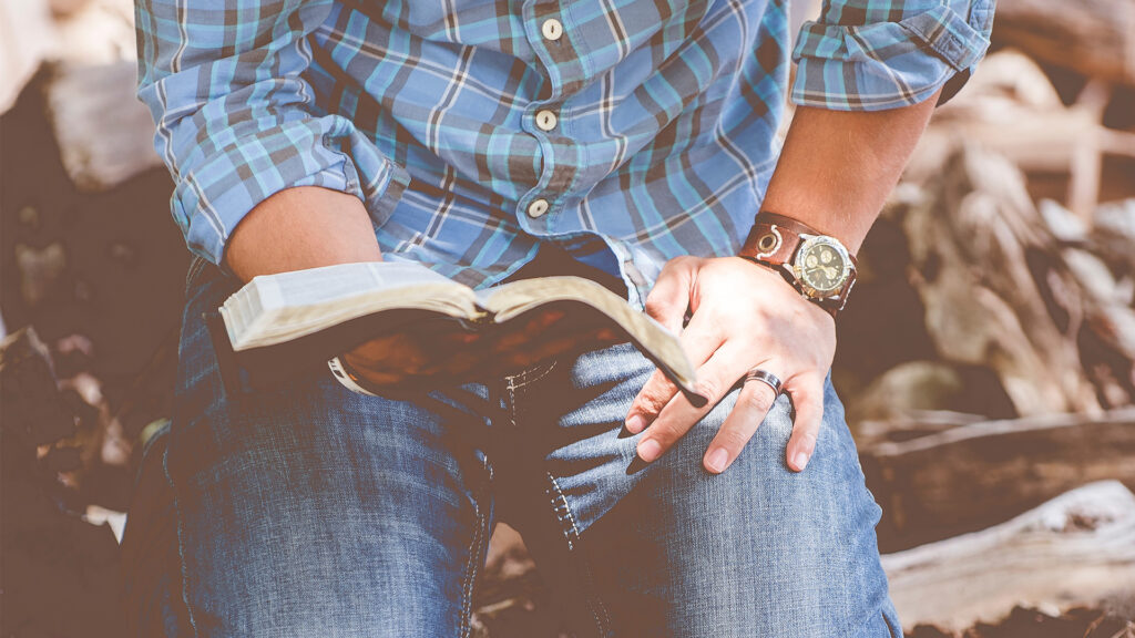 person-reading-book-while-kneeling