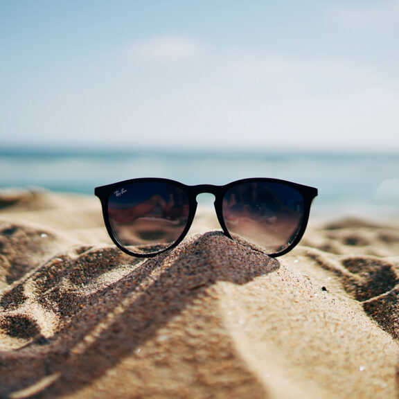 black-Ray-Ban-Wayfarer-sunglasses-on-beach-sand